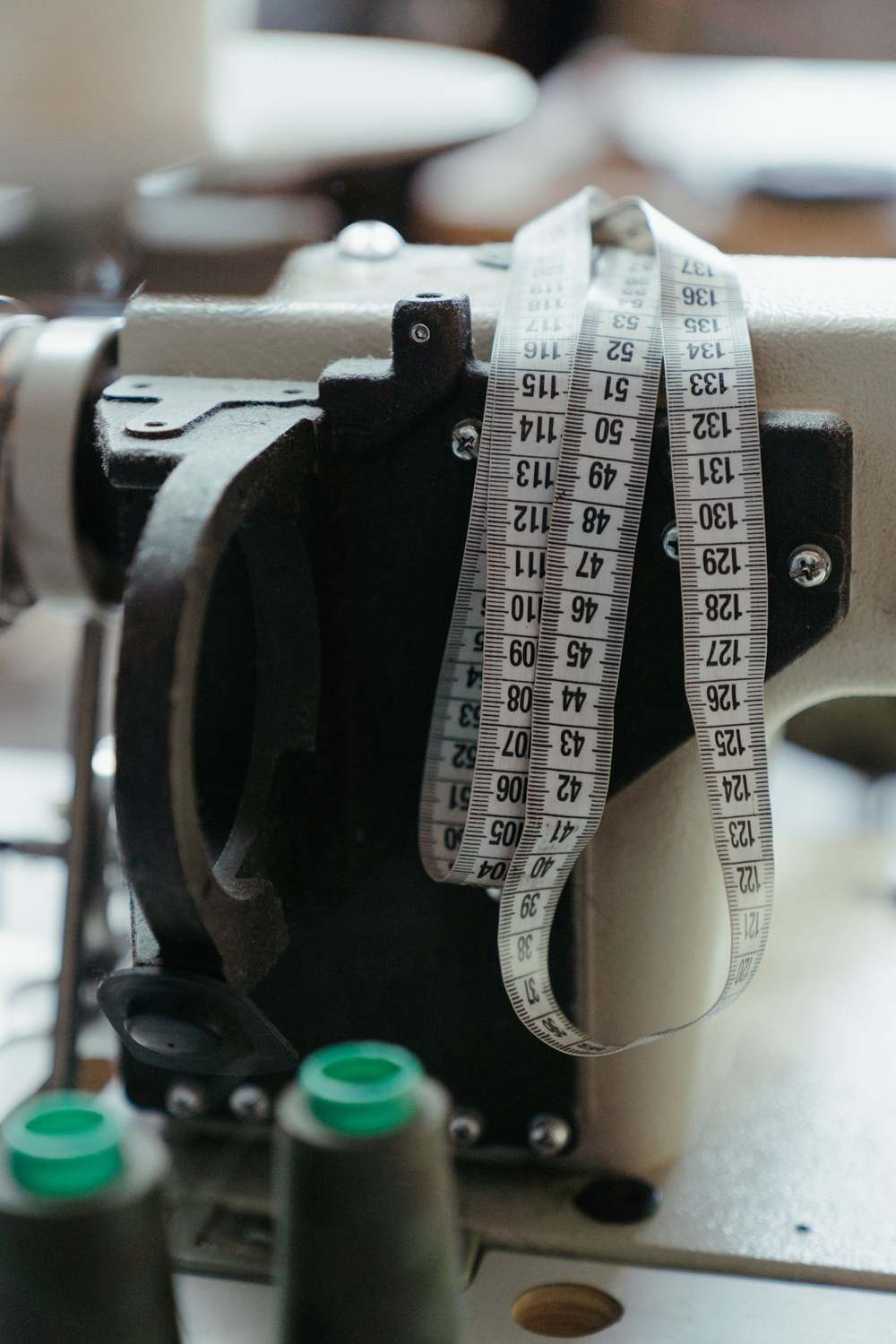 Mètre ruban de tailleur posé sur une machine à coudre