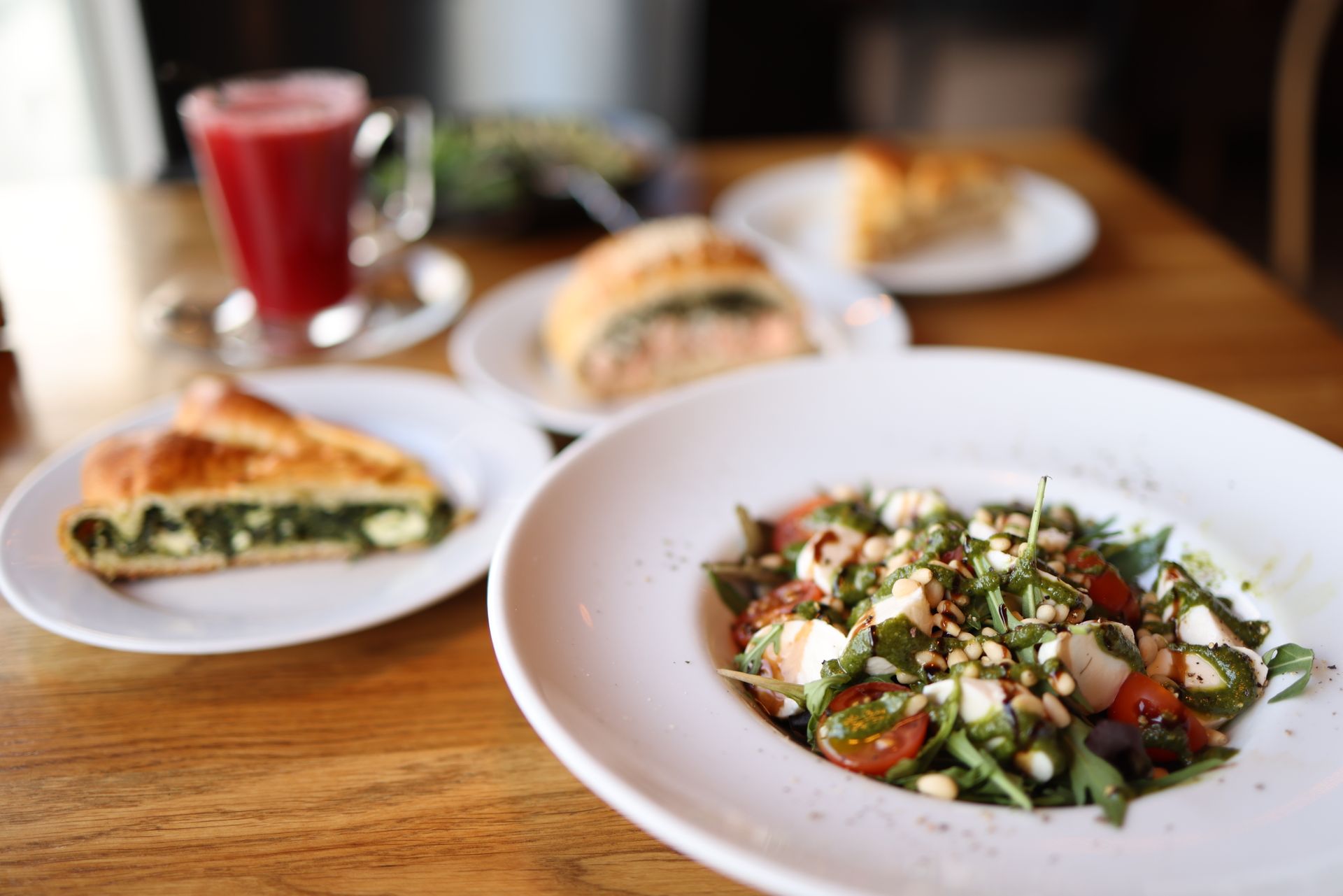 La table de midi — tartes, salade et jus, dans la lumière de la fenêtre