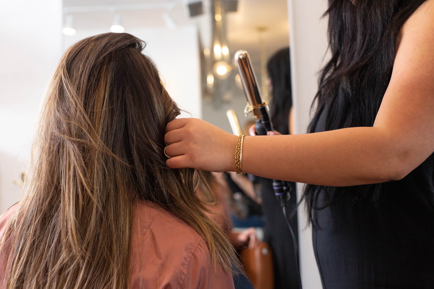 Le geste de la coiffeuse dans une longue chevelure