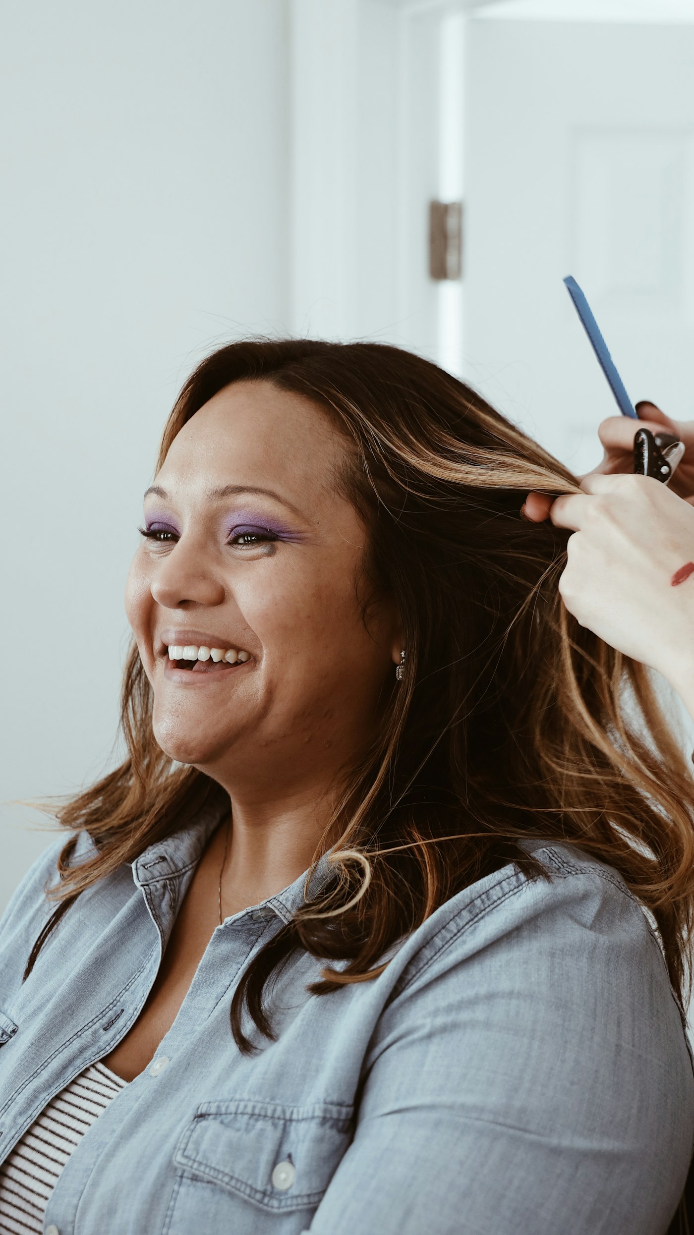 Une cliente sourit pendant son brushing chez Maison Léonie