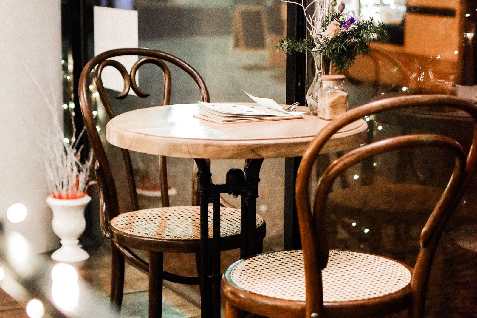 La table du coin fenêtre — chaises bistrot et carte du jour